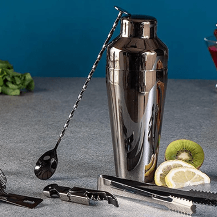 Black cocktail shaker with mixing spoon, tongs, strainer, and corkscrew.
