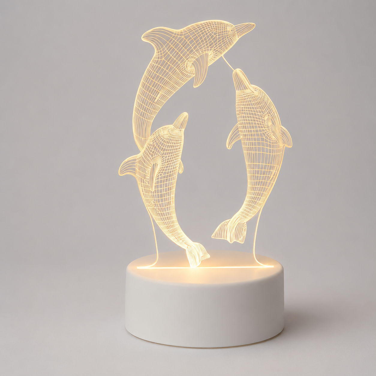 A 3D optical illusion LED night light featuring two dancing dolphins in a wireframe design, illuminated from within on a round white base against a neutral gray background.