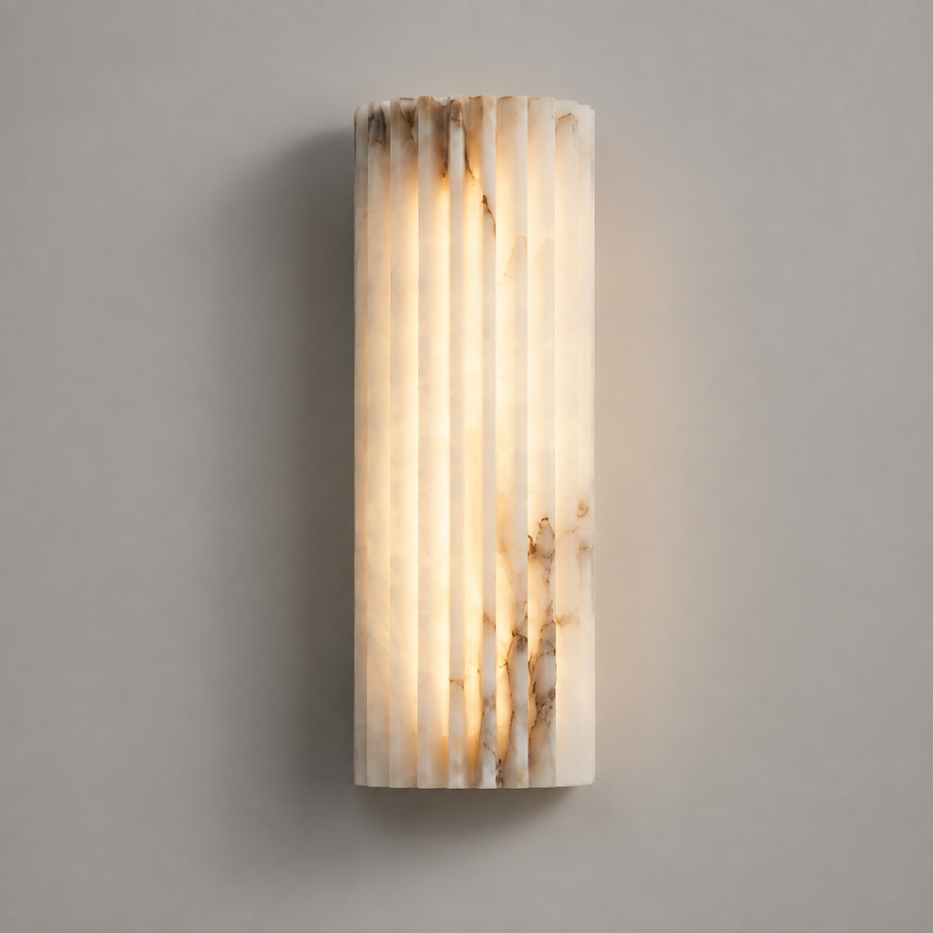 Vertical wall sconce with a softly glowing textured shade mounted on a light gray wall.