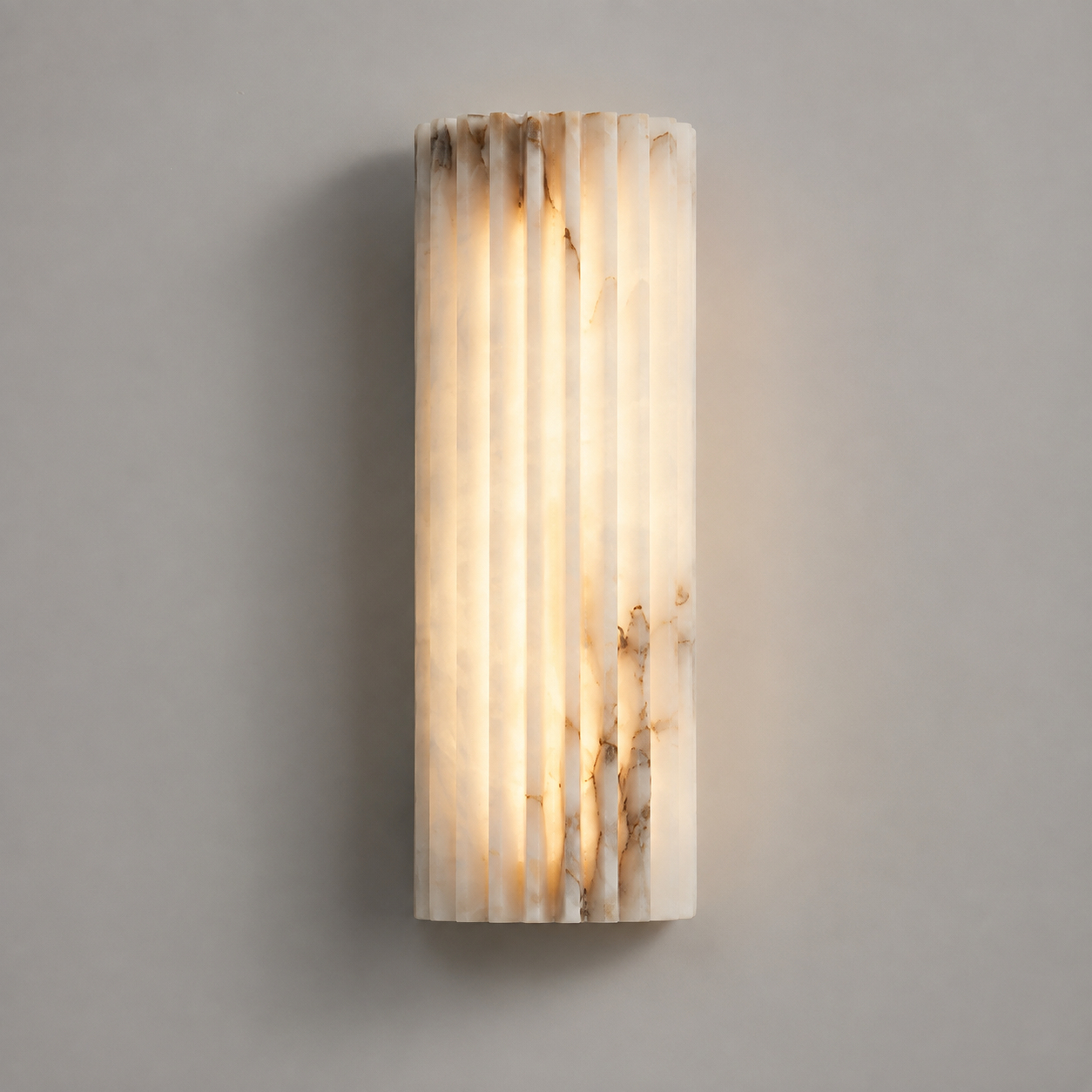 Vertical wall sconce with a softly glowing textured shade mounted on a light gray wall.