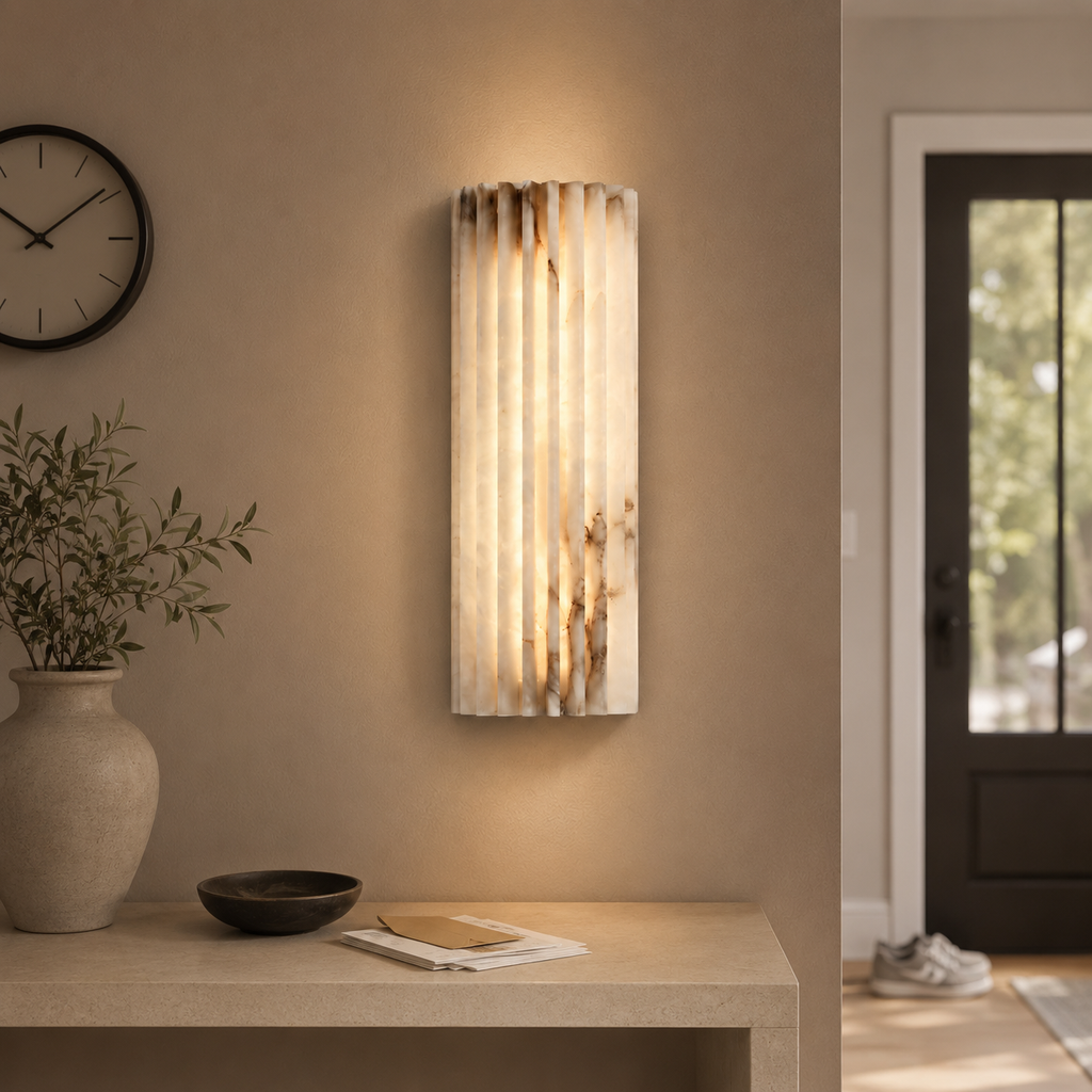 Vertical wall sconce mounted above a vanity in a neutral bathroom.