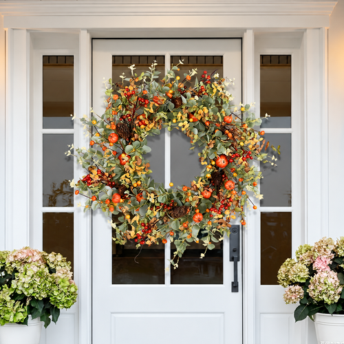 Artificial autumn harvest wreath hanging on a white front door