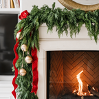 Artificial cedar garland on a fireplace mantel shown with separate red ribbon and bells