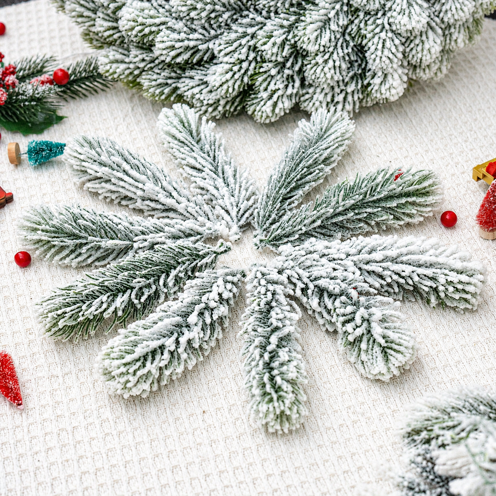 Snow flocked artificial cedar sprigs arranged with seasonal craft props
