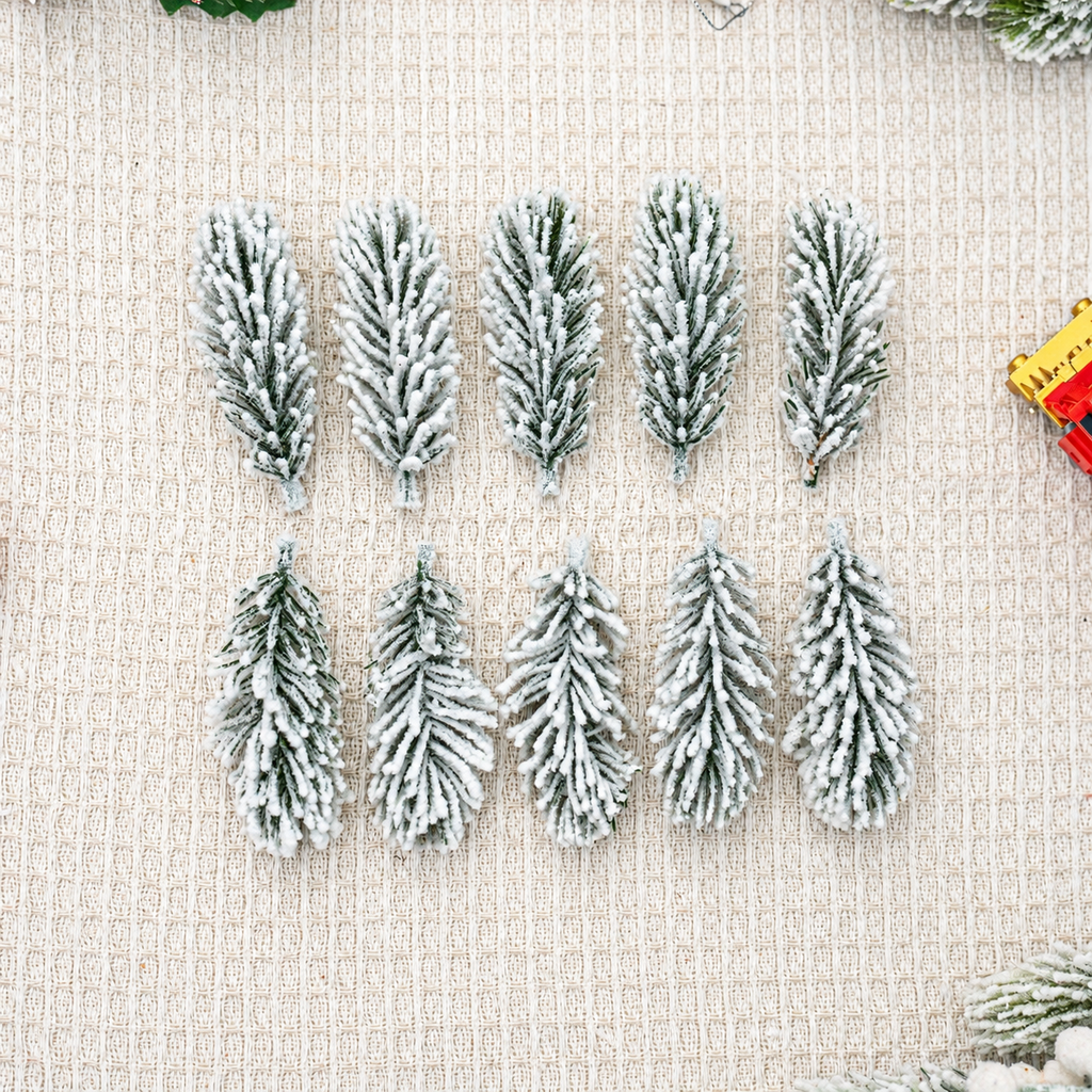 Ten snow flocked artificial cedar sprigs arranged on fabric