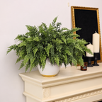 Artificial cedar sprigs styled in a separate vase on a mantel