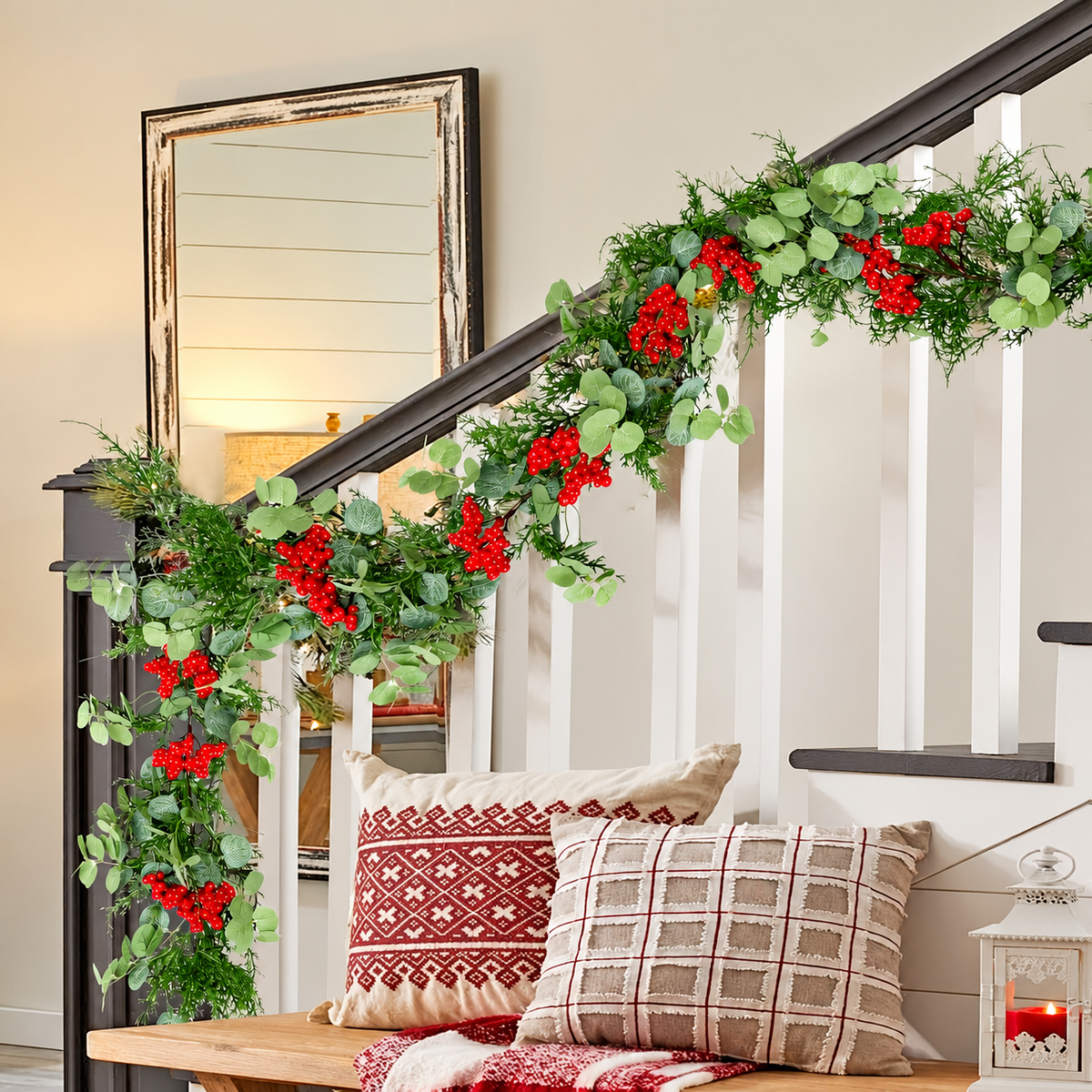 Artificial Christmas garland styled on a stair railing beside an entryway bench.