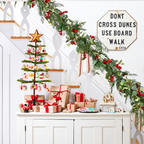 Artificial Christmas garland draped over a pale stair railing.