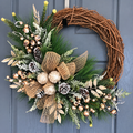 Cream and gold decorated artificial Christmas wreath hanging on a dark door