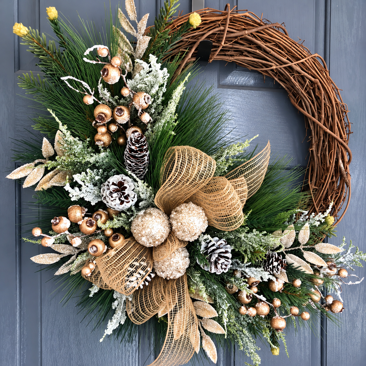 Cream and gold Christmas wreath with bow baubles and pinecones shown from the front