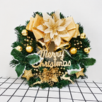 Gold decorated Christmas wreath displayed upright on a white tiled surface