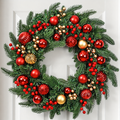Artificial Christmas wreath with red and gold baubles berries and pine style foliage on a white door