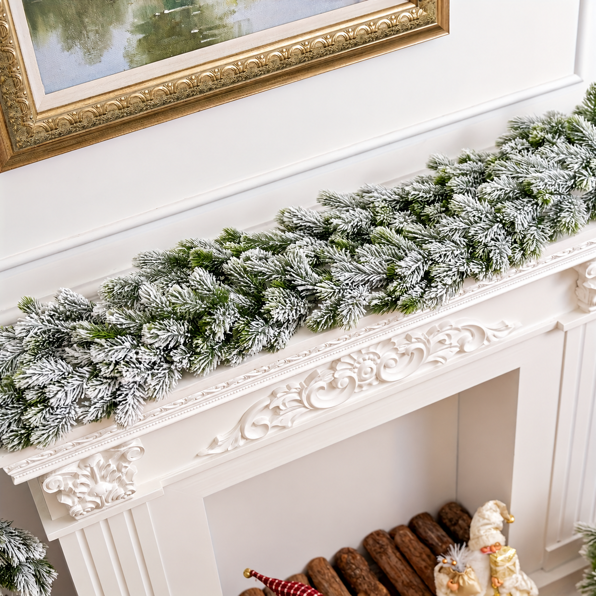 Snow flocked artificial evergreen garland on a white mantel viewed from above