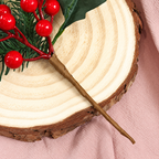 Close view of the wrapped stem beneath an artificial holly and pine pick