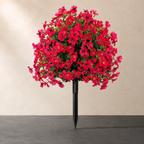 Rose red artificial outdoor flowers against ivory plaster and dark slate