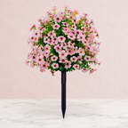 Pink artificial outdoor flowers against blush paper and white marble