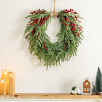 Artificial green pine and red berry wreath above a decorated mantel