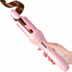 Pale pink automatic curler held around a section of hair