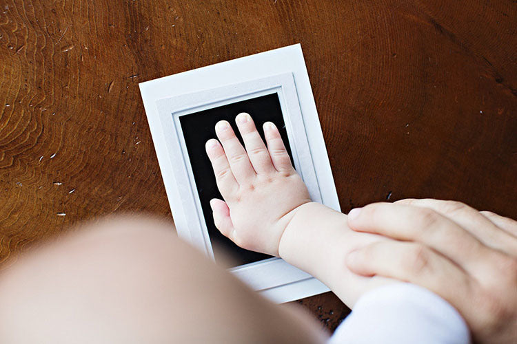 Baby handprint kit being used to capture a hand impression