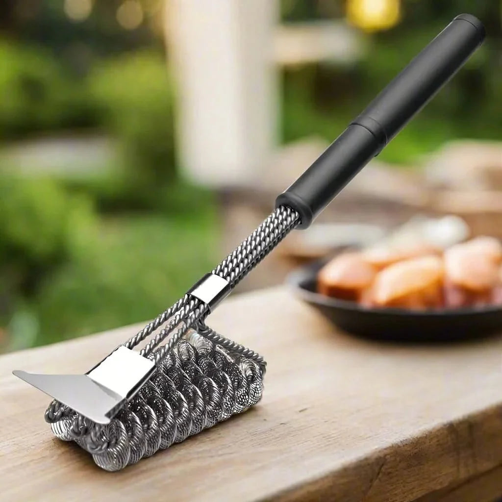 Bristle-free stainless steel grill brush positioned across a hot grill grate.
