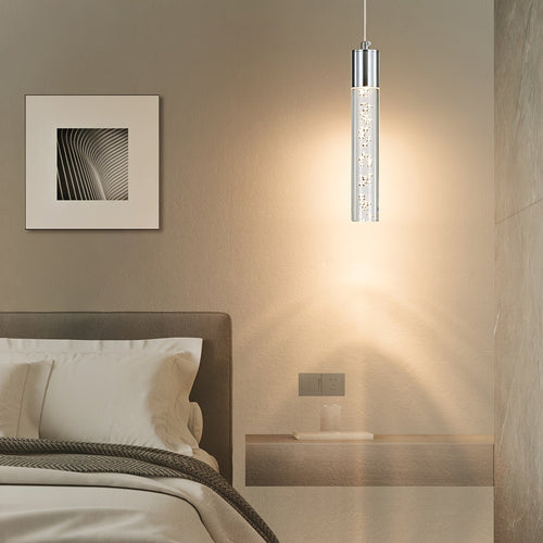 Single silver mini pendant with a clear bubble acrylic cylinder beside a bed