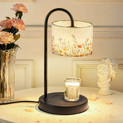 Candle warmer lamp with floral shade and dark base beside a jar candle.