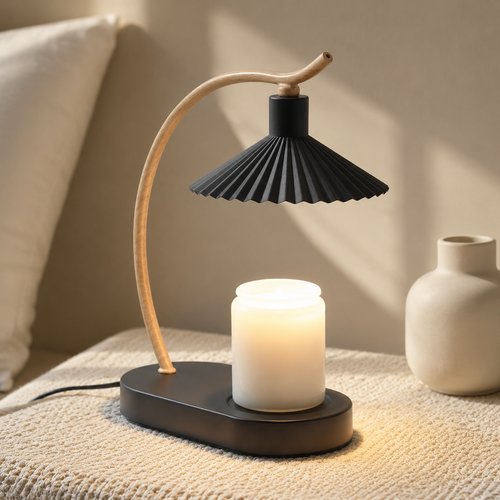 Black candle warmer lamp with a pleated shade warming a plain jar candle on a woven bedroom surface.