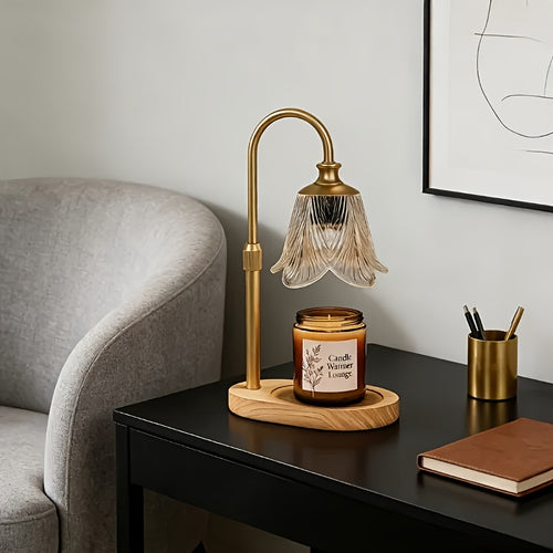 Gold candle warmer lamp with scalloped flower shade on a side table beside a chair.