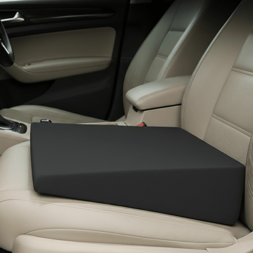 Black wedge cushion resting on a beige car passenger seat.