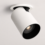 White adjustable cylindrical LED ceiling spotlight with a black interior, glowing warm white against a neutral ceiling.
