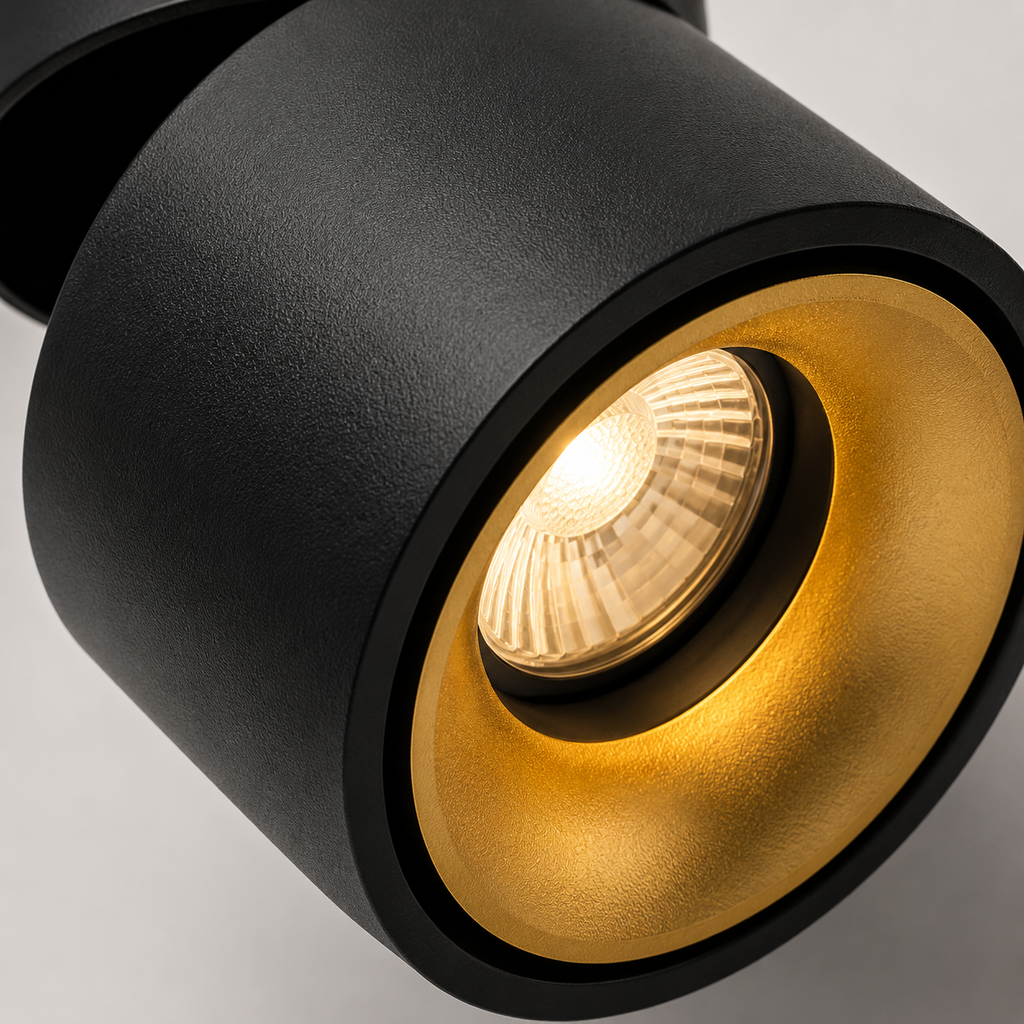 Hand adjusting round LED ceiling spotlight glowing warm white. 