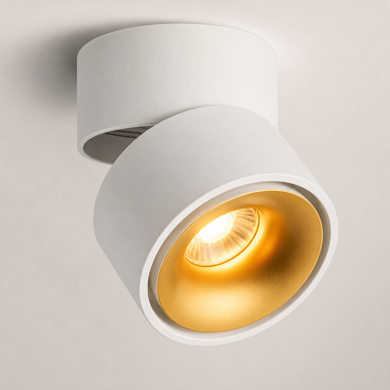 Hand adjusting round LED ceiling spotlight glowing warm white. 