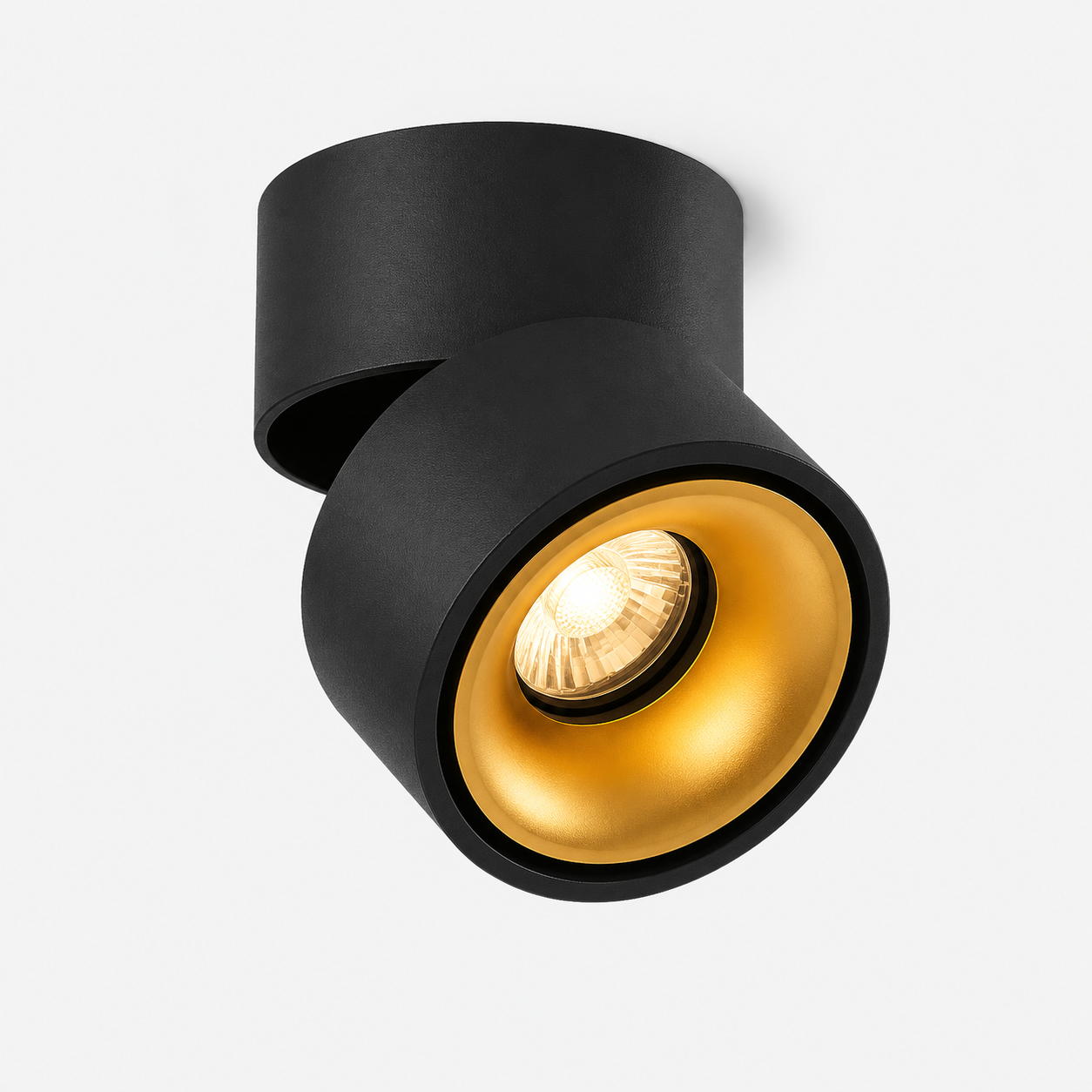 Hand adjusting round LED ceiling spotlight glowing warm white. 