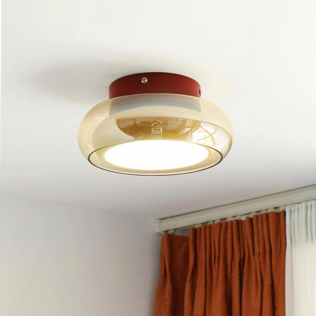 Amber glass ceiling light above a window with rust-colored curtains.