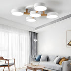 White ceiling light with five round shades and wood details above a living room.