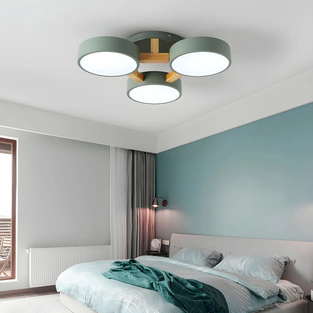 Green ceiling light with three round shades above a bedroom.