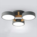 Gray ceiling light with three round shades and a wood support detail.