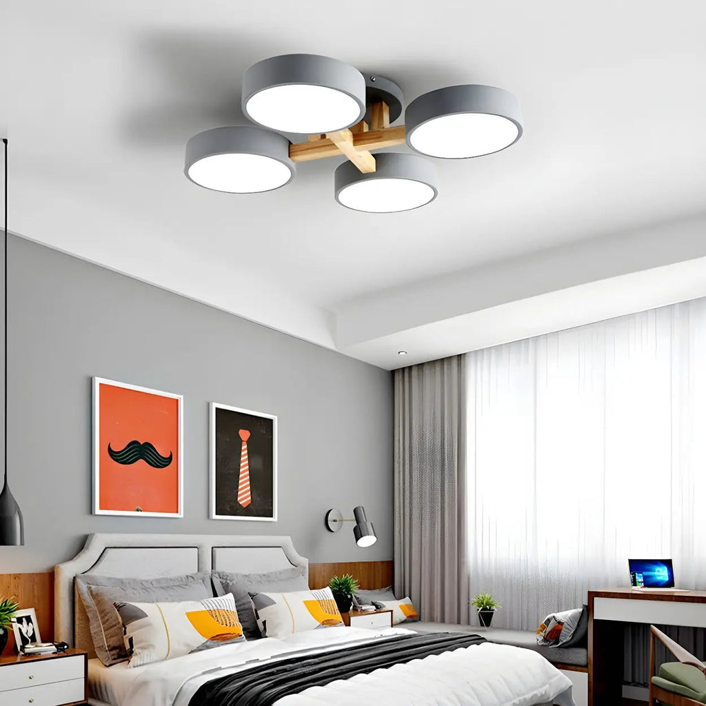 Gray ceiling light with four round shades above a bedroom.