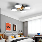 Gray ceiling light with four round shades above a bedroom.