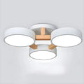 White ceiling light with three round shades and wood details.