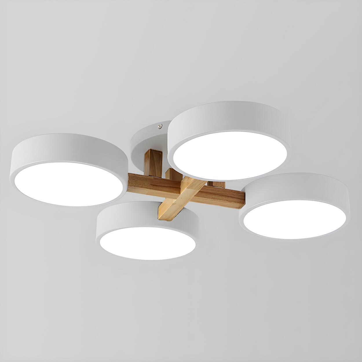 White ceiling light with four round shades and crossed wood details.
