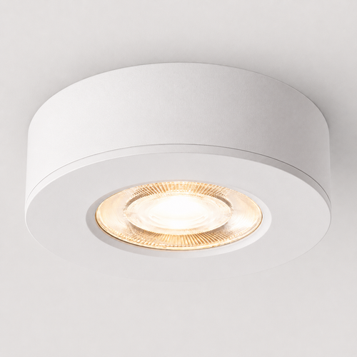 White ultra-thin round LED ceiling spotlight glowing warm white on a white ceiling.
