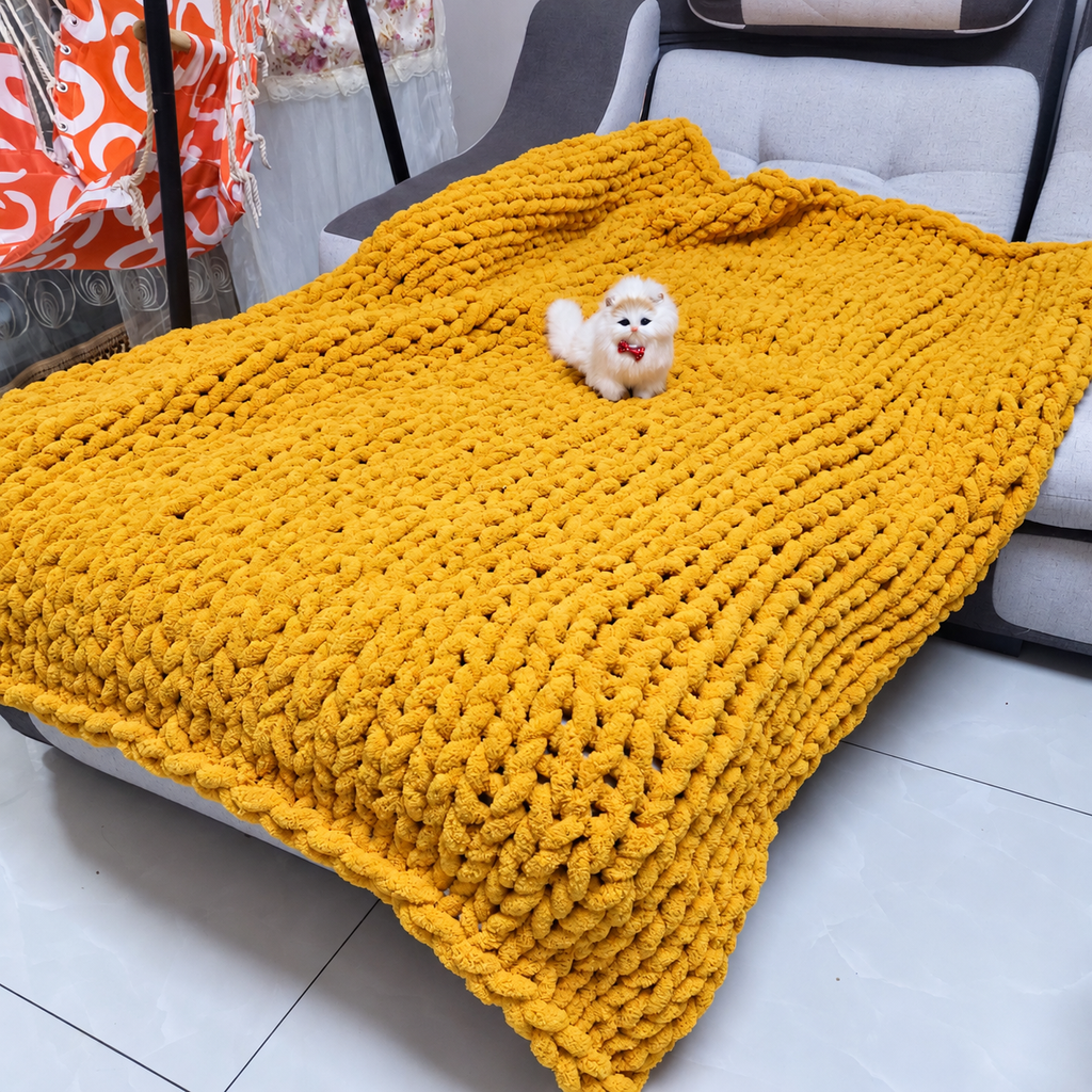 Yellow chunky chenille throw blanket spread over a dark sofa