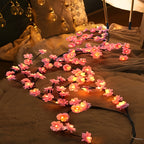 Pink blossom lights arranged over a bed