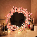 Blossom lights wrapped around a dressing table mirror