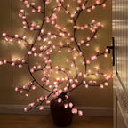Cherry blossom light branch beside a decorative vase