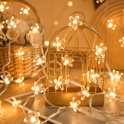 Cherry blossom fairy lights wrapped around a decorative birdcage.