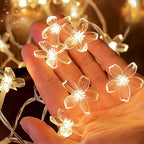 Cherry blossom fairy lights showing the clear flower covers against a hand.