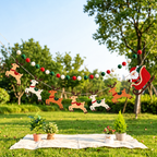 Christmas felt garland set hanging across a garden picnic display.