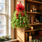 Green mesh tree shaped Christmas wreath hanging beside a window